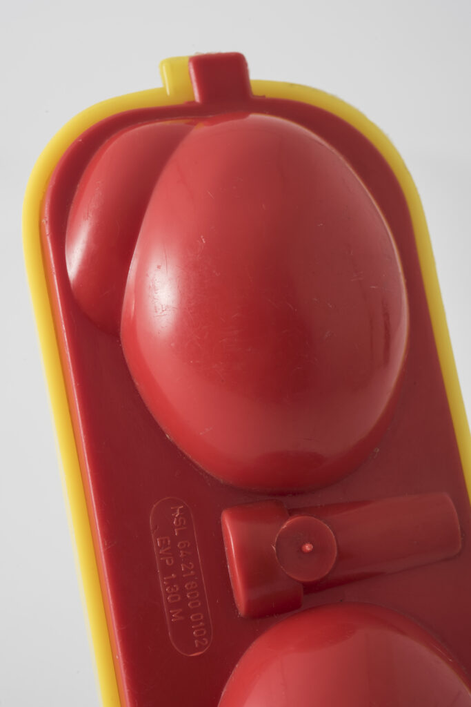 Egg box made of yellow and red plastic, close up