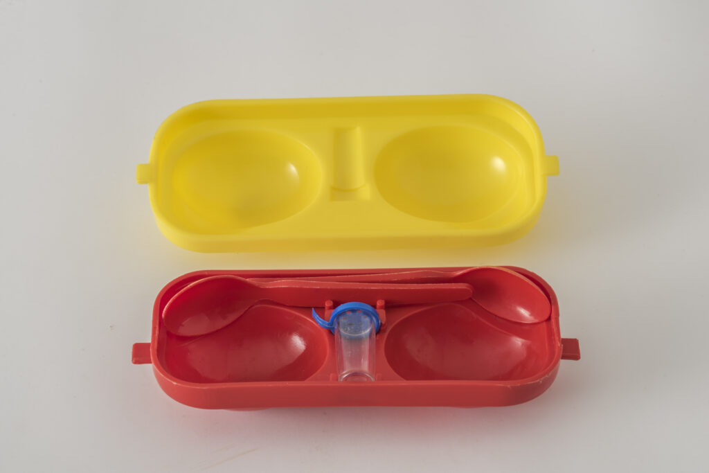 Egg box for two eggs made of yellow and red plastic, open