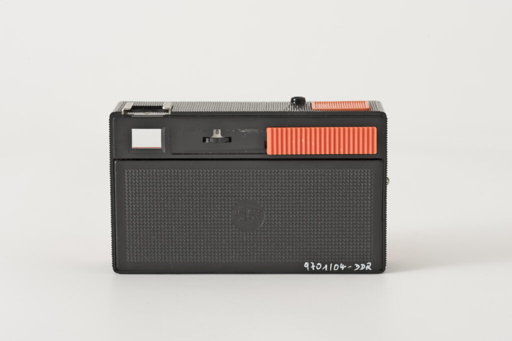 photographic camera, construction based on a black plastic casing with a coloured front shutter in bright orange