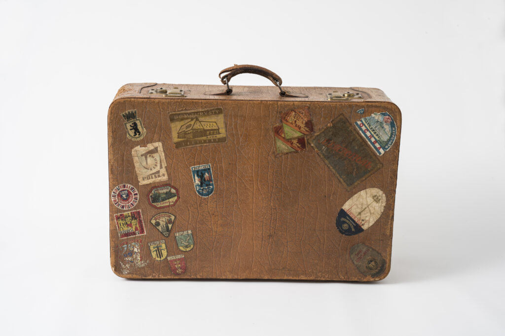 suitcase with a brown leather cover and sticker