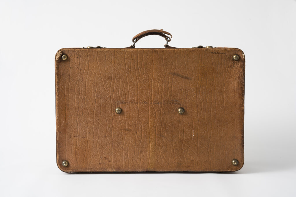 suitcase with a brown leather cover, backside with brass details