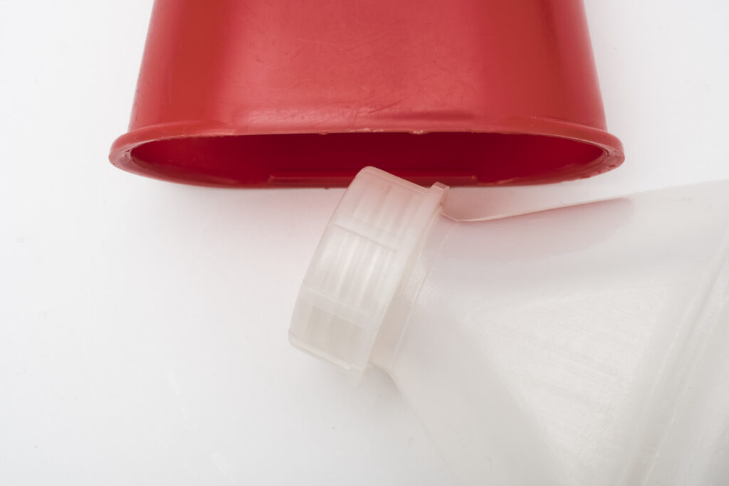 drinking bottle made of transparent plastic with a red lid, close up of the lid and the bottleneck